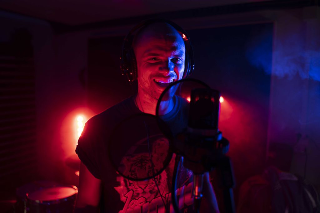 cantante sorride durante una sessione in studio di registrazione